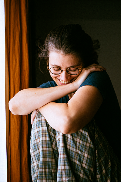 photographie portrait de Mathilde Gaborieau devant une fenetre avec bras en calin